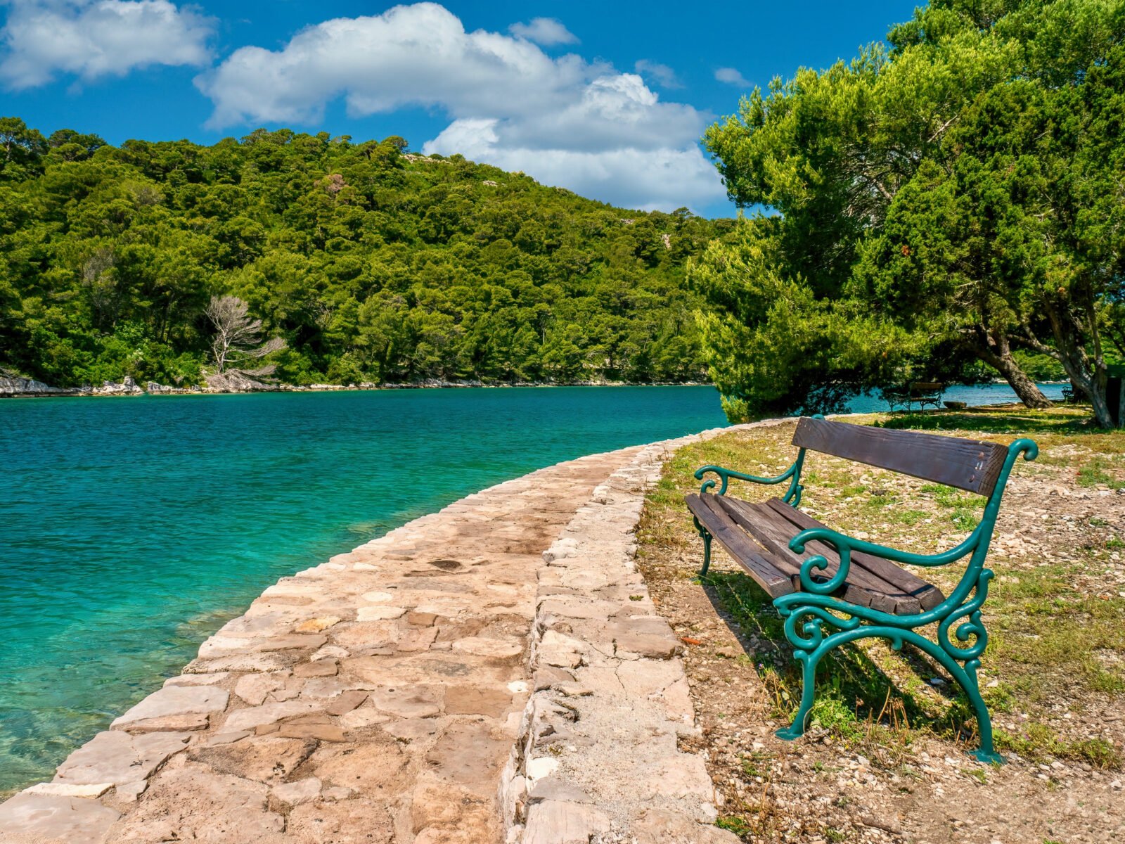 A,Rustic,Wooden,And,Wrought,Iron,Bench,Sits,Empty,Beside